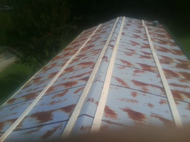 Rusted metal roof panels with new wood purlins before replacement — Storm Damage Roof Repair in Olney Springs by Roofing Brothers